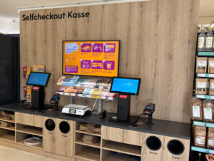 Zwei Self-Checkout-Kassen mit Waage für Frischeprodukte stehen am Ausgang