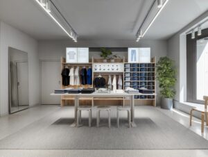 Monochromer Terrazzo Boden trifft auf warme Grautöne, Eichenmöbel und Grünpflanzen im Obergeschoss