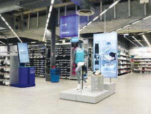 Gondeln mit Look-Demo an Display-Mannequins und Produkterklärung, links die Discovery Station