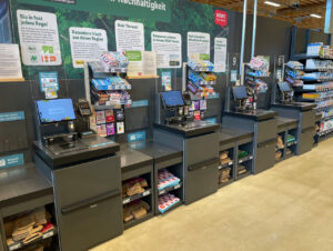Die Self-Checkout-Kassen werden von einem Mitarbeitenden betreut und mit Kameras überwacht