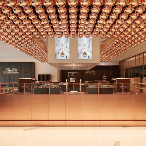 Das Café mit seinen 80 Sitzplätzen und Außenterrasse in den Corporate Colours Kupfer und Schokoladenbraun.